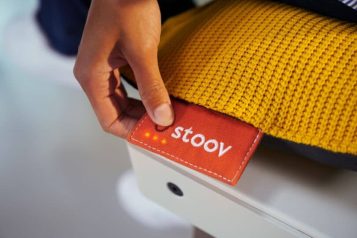 Person pressing a red tag attached to a heating pillow to turn it on